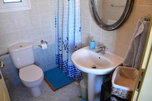 a bathroom with a toilet and a sink and a mirror at Aegina3views in Kipséli +15 photos
