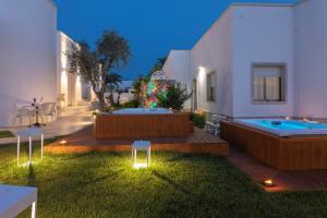 a backyard with a swimming pool and a house at Le Gemelle Boutique Hotel in Torre Suda