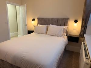 a bedroom with a large bed with white sheets and pillows at Rambler's Rest Boutique Apartment in Westward Ho