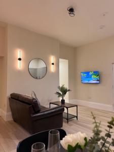 a living room with a couch and a mirror at Rambler's Rest Boutique Apartment in Westward Ho