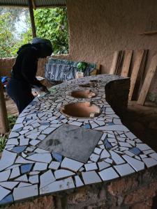 a person standing next to a table with a mosaic counter top at Paradise Resort in Chabahinga