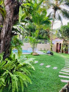 a yard with a swimming pool and palm trees at Thambara Villa Unawatuna in Unawatuna