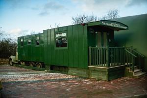 a green train car parked next to a building at The Truck in Longframlington