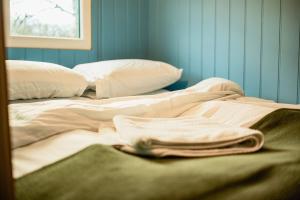 a messy bed in a room with blue walls at The Truck in Longframlington