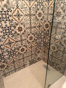 a bathroom with a shower with a tile wall at Dar Bleu Pearl in Chefchaouen +53 photos