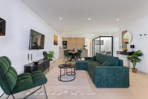 a living room with a green couch and chairs at Serenity Garden & Spa in Los Alcázares