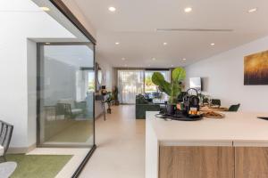 a kitchen and living room with white walls and white countertops at Serenity Garden & Spa in Los Alcázares