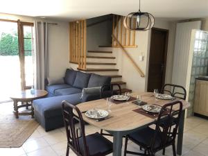 a living room with a table and a blue couch at Le relais de la motte in Thuré