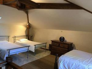 a bedroom with two beds and a wooden dresser at Le relais de la motte in Thuré