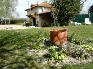 a vase sitting in the grass in front of a house at Le relais de la motte in Thuré +4 photos