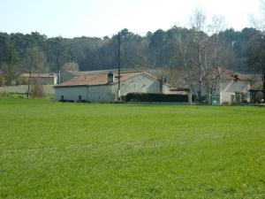 a field of green grass with a house in the background at Le relais de la motte in Thuré