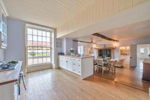 a large kitchen and living room with a table and chairs at Old Ford House in Blandford Forum