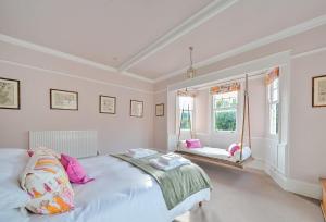 a white bedroom with a bed and a window at Old Ford House in Blandford Forum