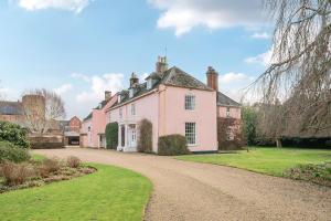 a large pink house with a gravel road at Old Ford House in Blandford Forum