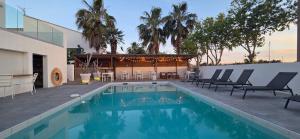 a swimming pool with chairs and a house at La Perle du Voyageur in Agde