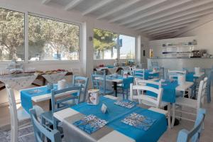 a restaurant with blue and white tables and chairs at Le Gemelle Boutique Hotel in Torre Suda