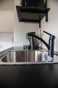 a sink in a kitchen with a faucet at Sfeervol appartement voor 2 personen De Jonge Blomme in Kamperland