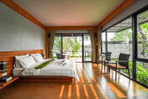 a bedroom with a bed and large windows at The Grace Amphawa in Amphawa +97 photos
