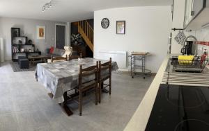a living room with a dining room table with chairs at Gîte des voines in Maillé