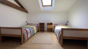 a bedroom with two beds and a window at Gîte des voines in Maillé