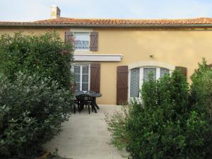 a patio of a house with a table and chairs at Gîte des voines in Maillé