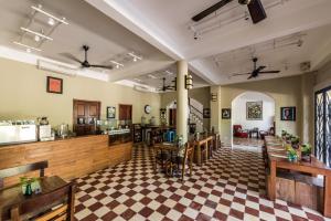 a restaurant with tables and chairs in a room at The Columns in Kampot