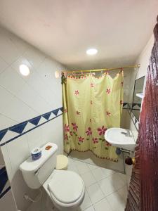 a bathroom with a toilet and a shower curtain at Refugio Pantu in Cabo de la Vela