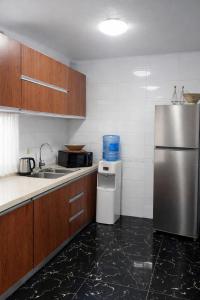 a kitchen with a stainless steel refrigerator and a sink at Condominio hortencia in Viana