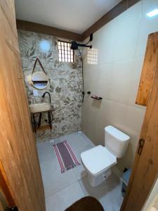 a bathroom with a toilet and a sink at Recanto do Ofurô in Ilhéus +34 photos