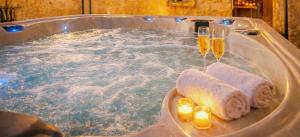 ein Whirlpool mit zwei Champagnergläsern und Kerzen. in der Unterkunft Le1693 - Charme & confort 4 étoiles - Jacuzzi in Limoux