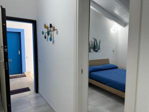 a bedroom with a blue bed and a doorway at AZZURRO meraviglioso attico a pochi passi dal mare in Valledoria