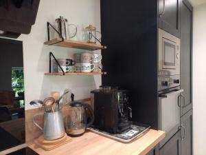 a kitchen counter with a microwave and a coffee maker at Domaine la jarrie in La Bussière