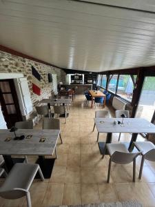 a restaurant with tables and chairs in a room at Le Cantou in Affieux