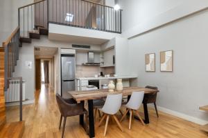 a kitchen and dining room with a wooden table and chairs at Flateli Nord in Girona