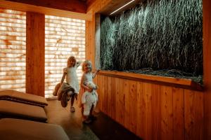 two girls standing in a room with an aquarium at Tylickie Wzgórze SPA & Wellness - basen, sauna, siłownia, atrakcje dla dzieci in Tylicz +148 photos