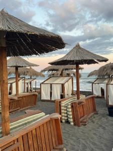 a group of umbrellas and chairs on a beach at Hotel Dragoi in Velipojë