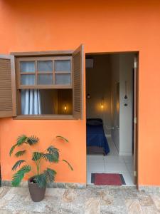 a house with a window and a plant in the doorway at Pouso Clara Mar in Paraty