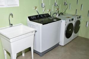 a laundry room with a washing machine and a sink at Duncan Street Guesthouse in Georgetown