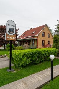 un panneau dans l'herbe devant une maison dans l'établissement Auberge Mr James, à Rivière-du-Loup