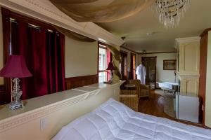 a bedroom with a bed and a living room at Auberge Mr James in Rivière-du-Loup