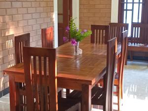 a wooden table with chairs and a vase with flowers on it at Villa Sol in Kamburugamuwa