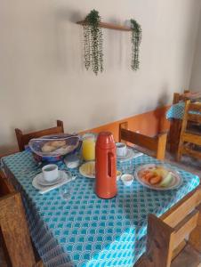 a table with a blue table cloth with food on it at Pouso Clara Mar in Paraty