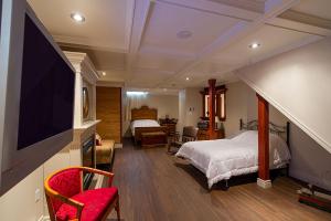 a bedroom with a bed and a flat screen tv at Auberge Mr James in Rivière-du-Loup