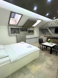 a bedroom with a white bed and a table and a tablektop at Motel Marco Polo in Gredice