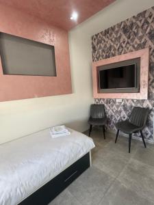 a bedroom with a bed and a flat screen tv at Motel Marco Polo in Gredice