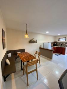a kitchen and living room with a table and a couch at Recanto do Ofurô in Ilhéus