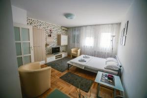 um pequeno quarto com uma cama e uma mesa em Apartment Stela em Belgrado