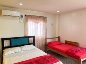 a bedroom with two beds and a window at Refugio Pantu in Cabo de la Vela