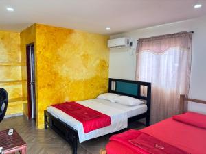 a bedroom with two beds and a yellow wall at Refugio Pantu in Cabo de la Vela +30 photos