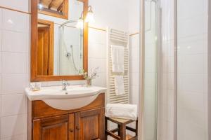 a bathroom with a sink and a mirror and a shower at La Corte Medicea in Montepulciano